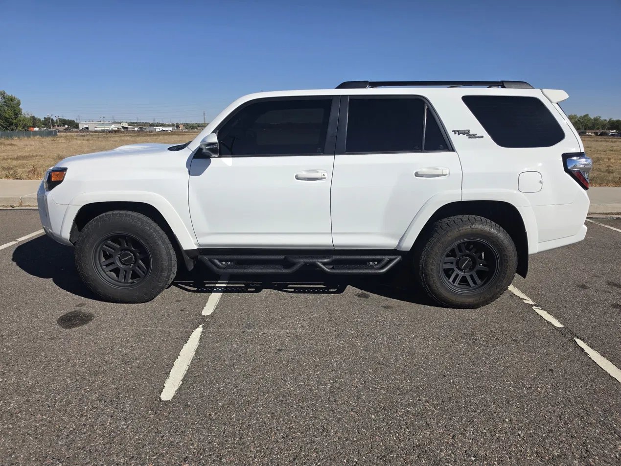 White Toyota 4Runner TRD Off-Road with black drop-step running boards