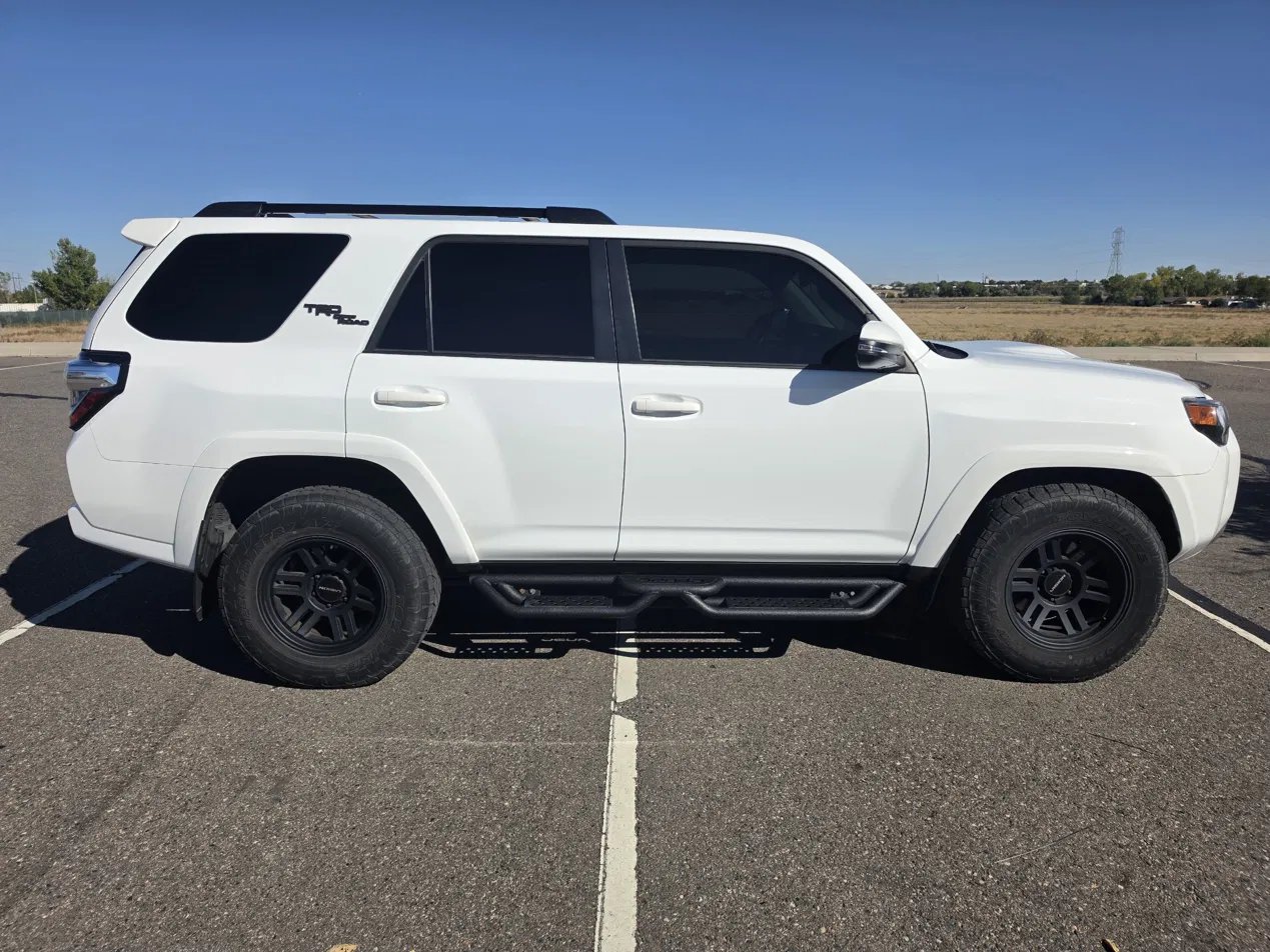 Passenger side of white 4Runner with drop-step running boards